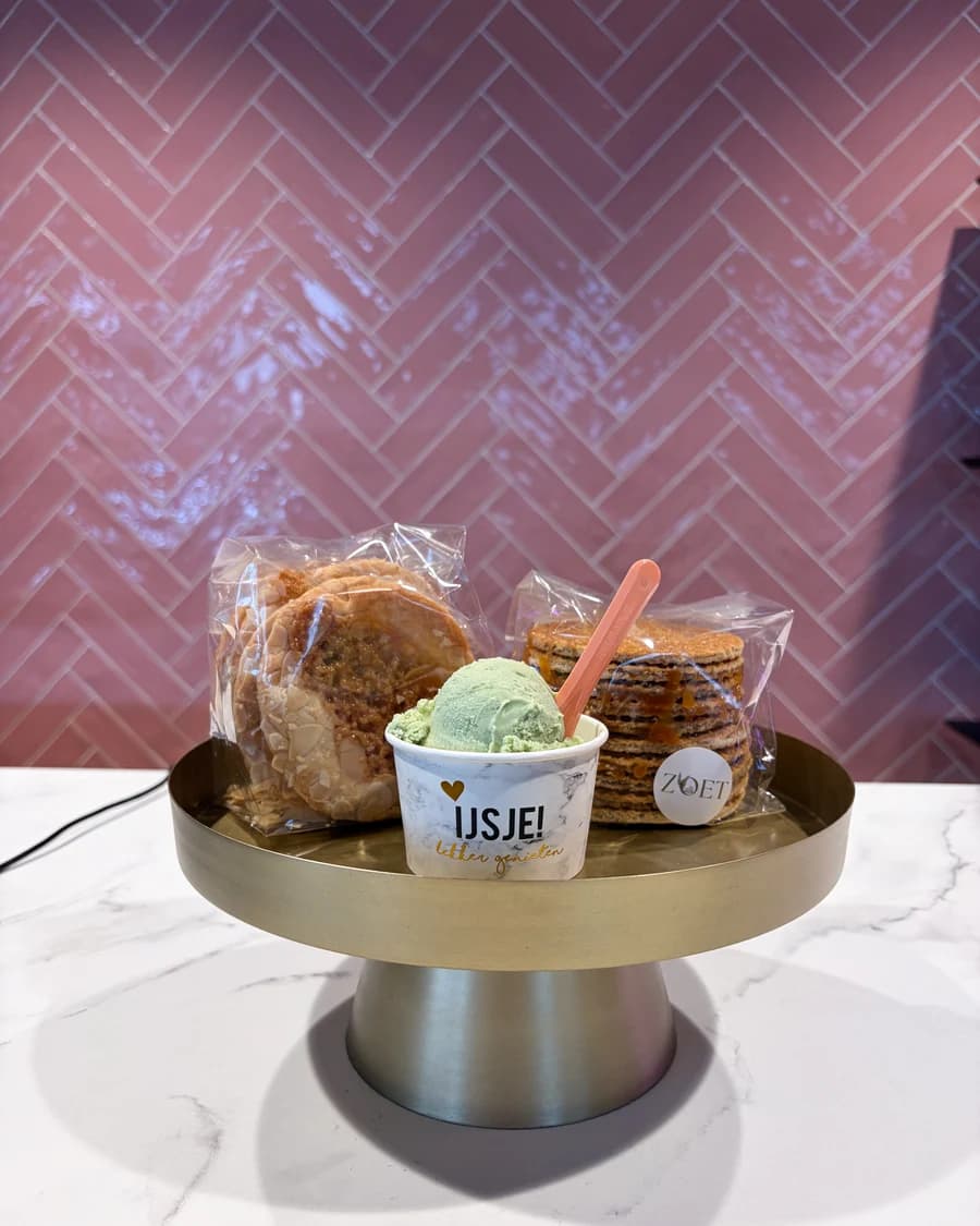 Een bakje pistache-ijs op een gouden schaal, met stroopwafels en koeken van Bakkerij Zoet